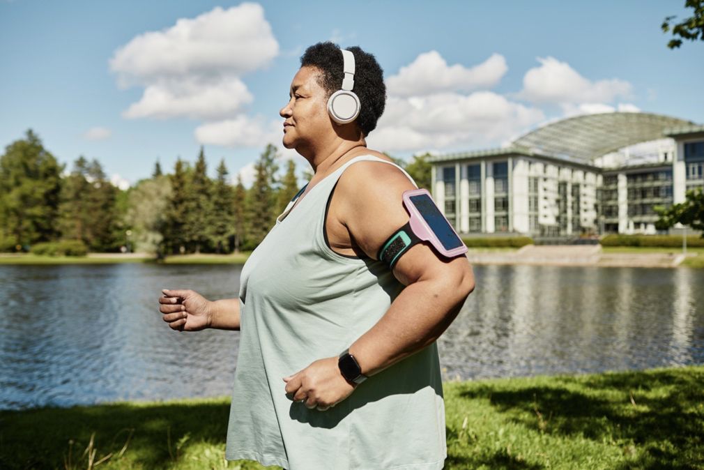 Side view portrait of a mature black woman running outdoors