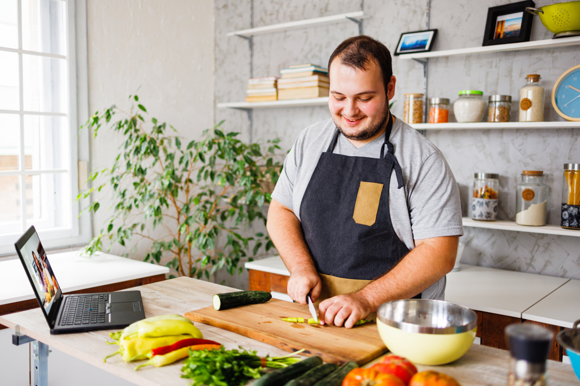 Happy man cooking healthy meal in kitchen