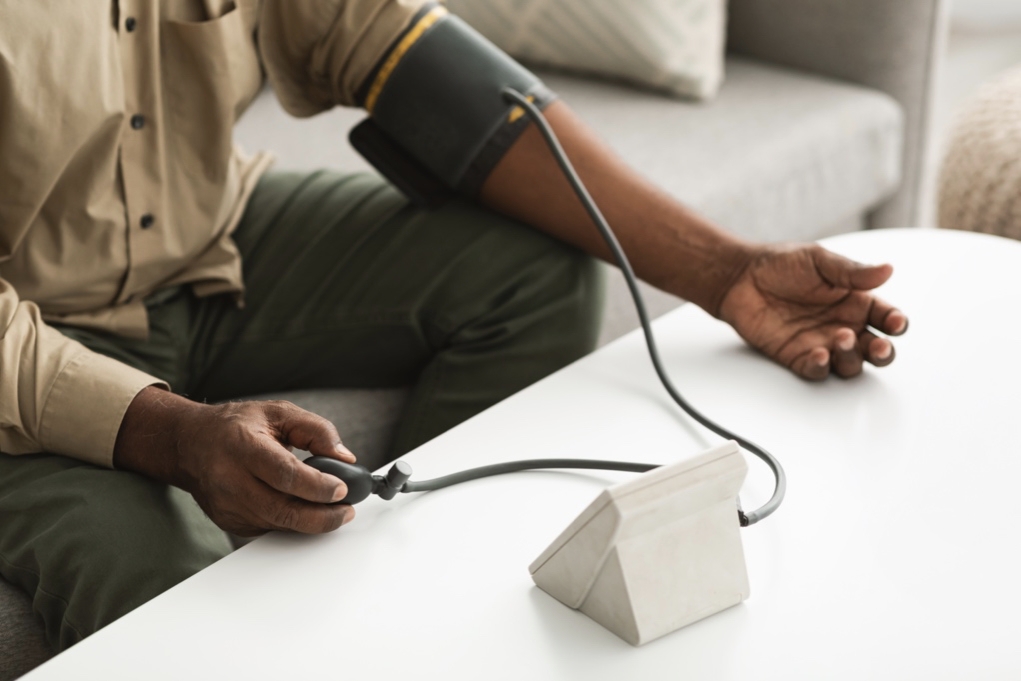 African-American man measuring blood pressure at home