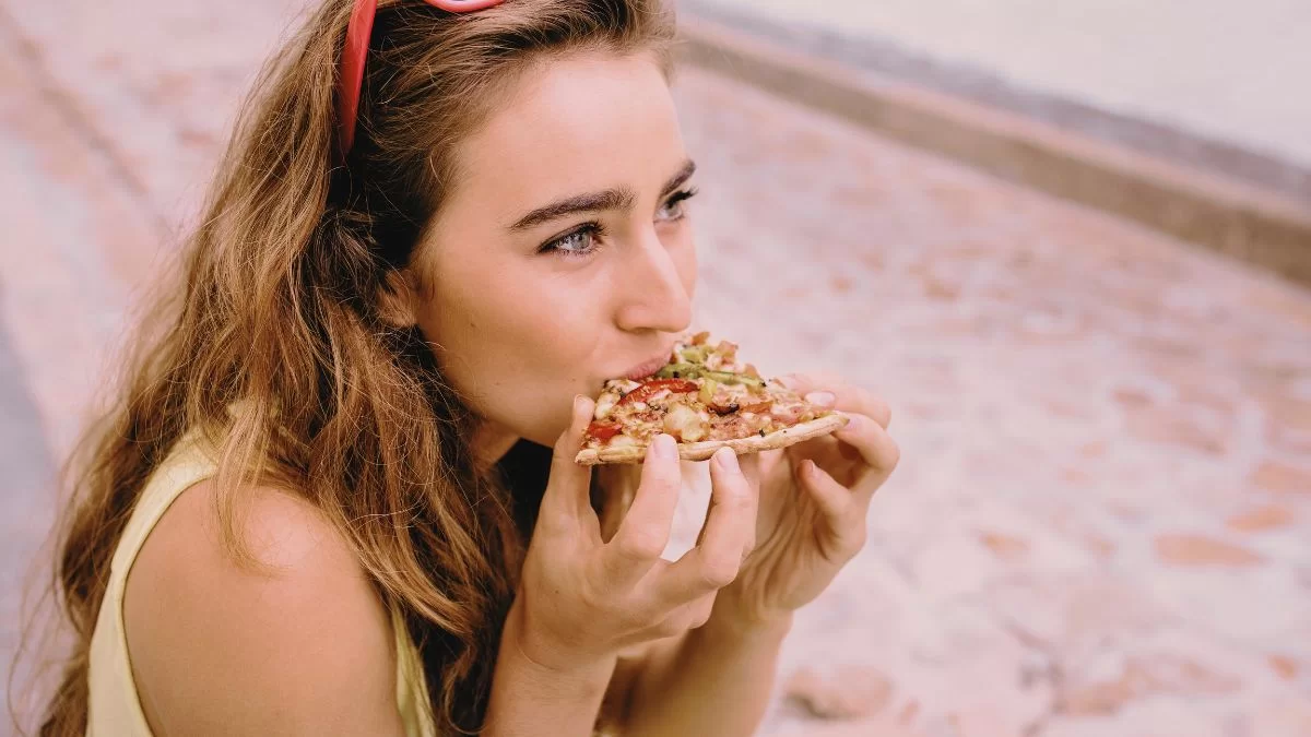 Woman Eating A Slice Of Pizza