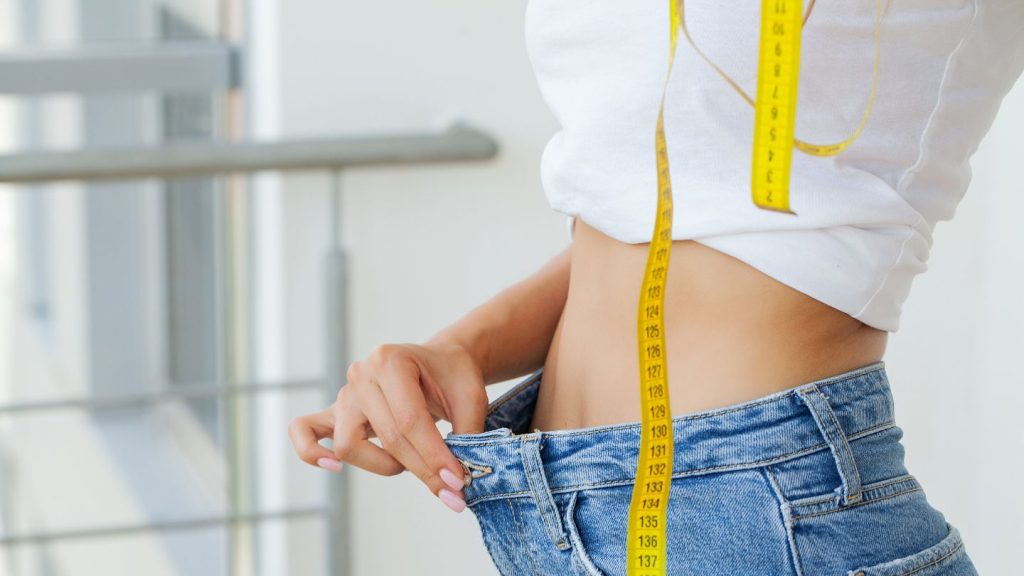 Woman Measuring Waist With Measure Tape 